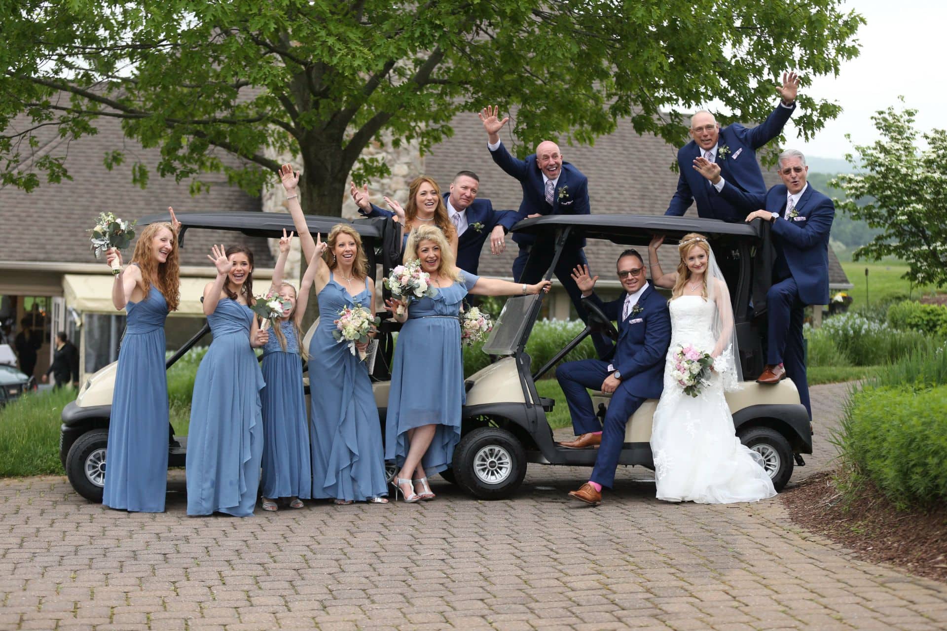 Wedding party smiling and celebrating and posing in front of a Golf cart at Country club