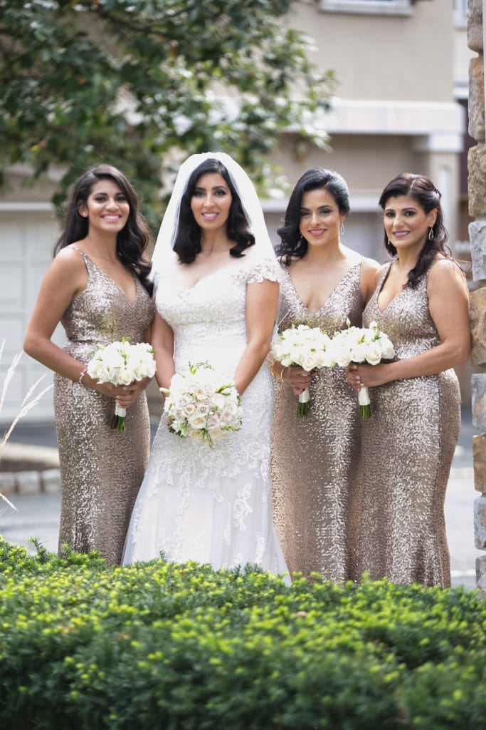 Muslim bridesmaids wearing gold bridemaid dresses posing with bride