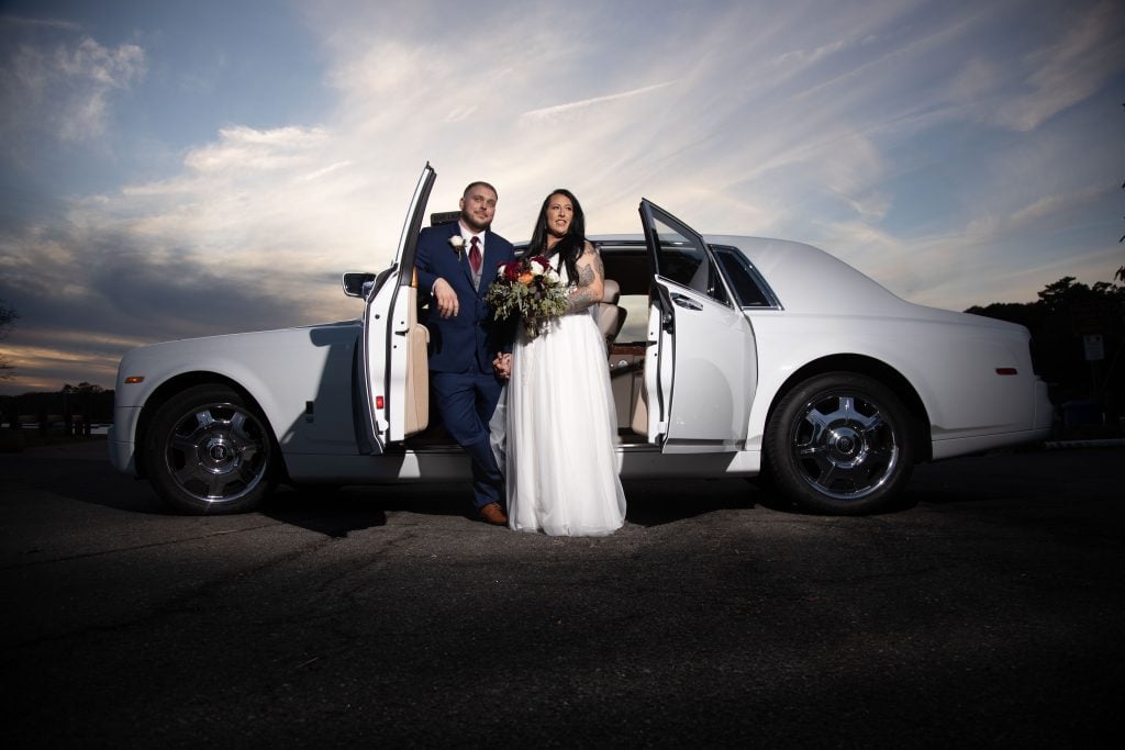 Groom-and-Plus-size-bride-standing-in-front-of-Rolls-Royce-at-sunset-at-Glen-Island