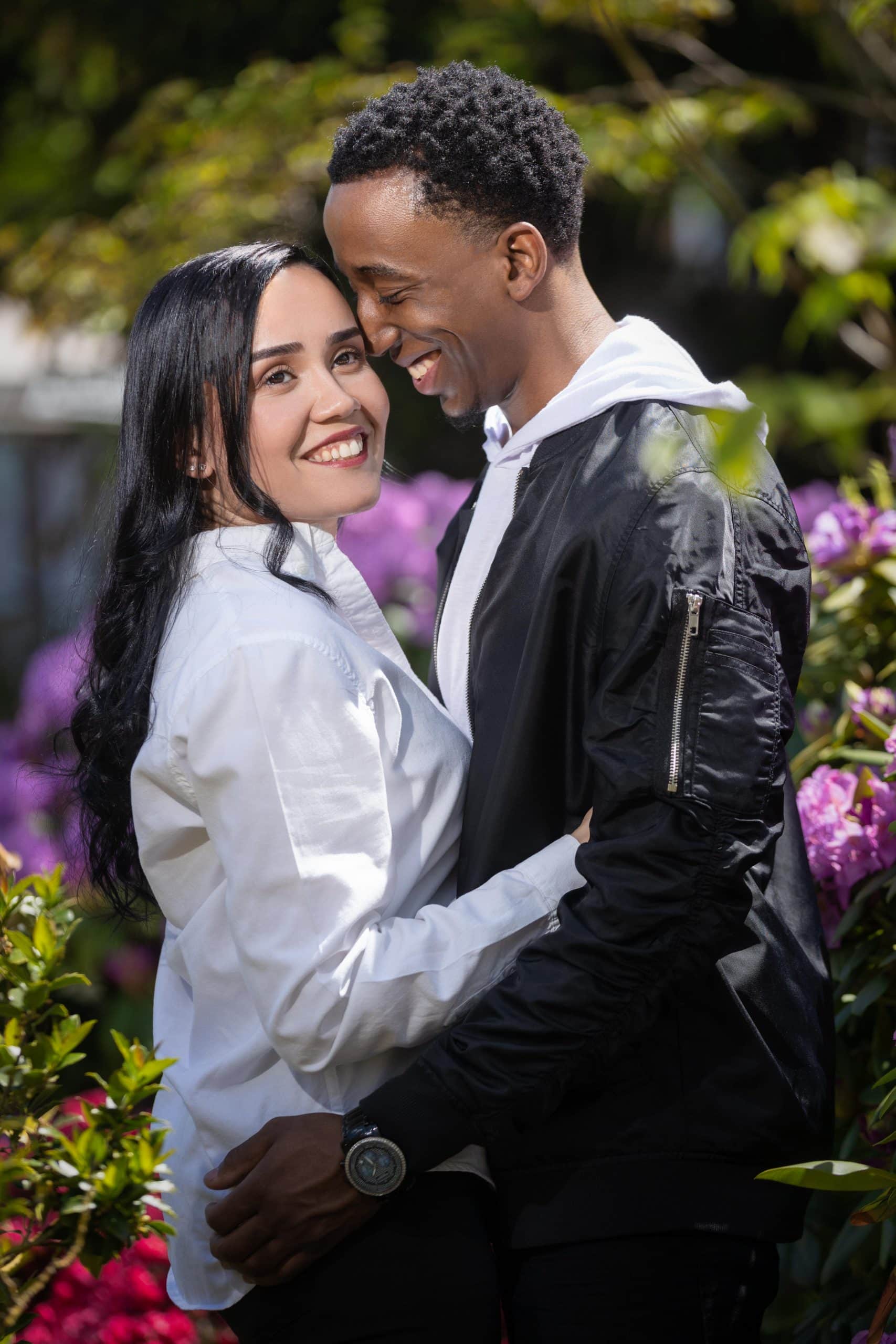 Interracial Couple hugging and caressing in garden in Palmer Square in Princeton