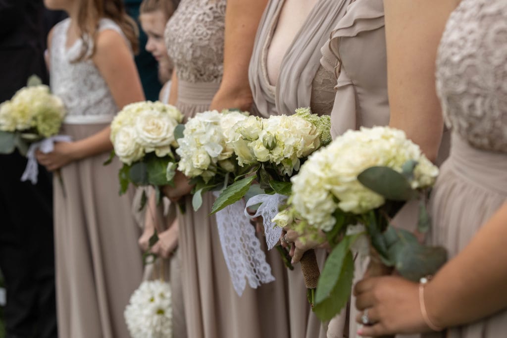 Champagne-bridesmaid dresses holding white-hydrangea-bouquets