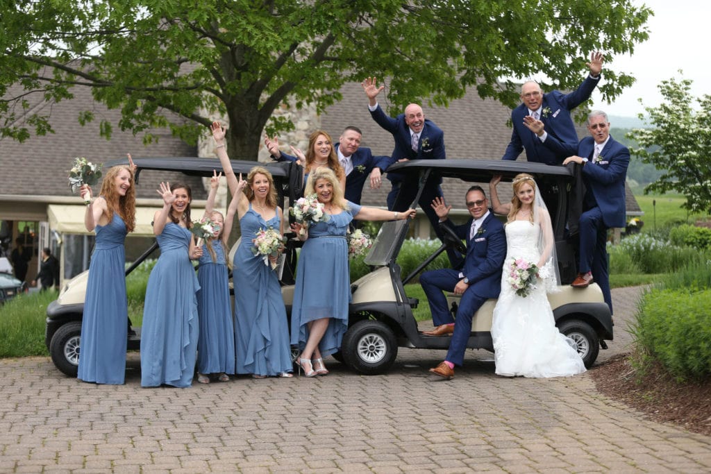 bridesmaids in blue- bridesmaid dresses posing front of golf cart having fun at