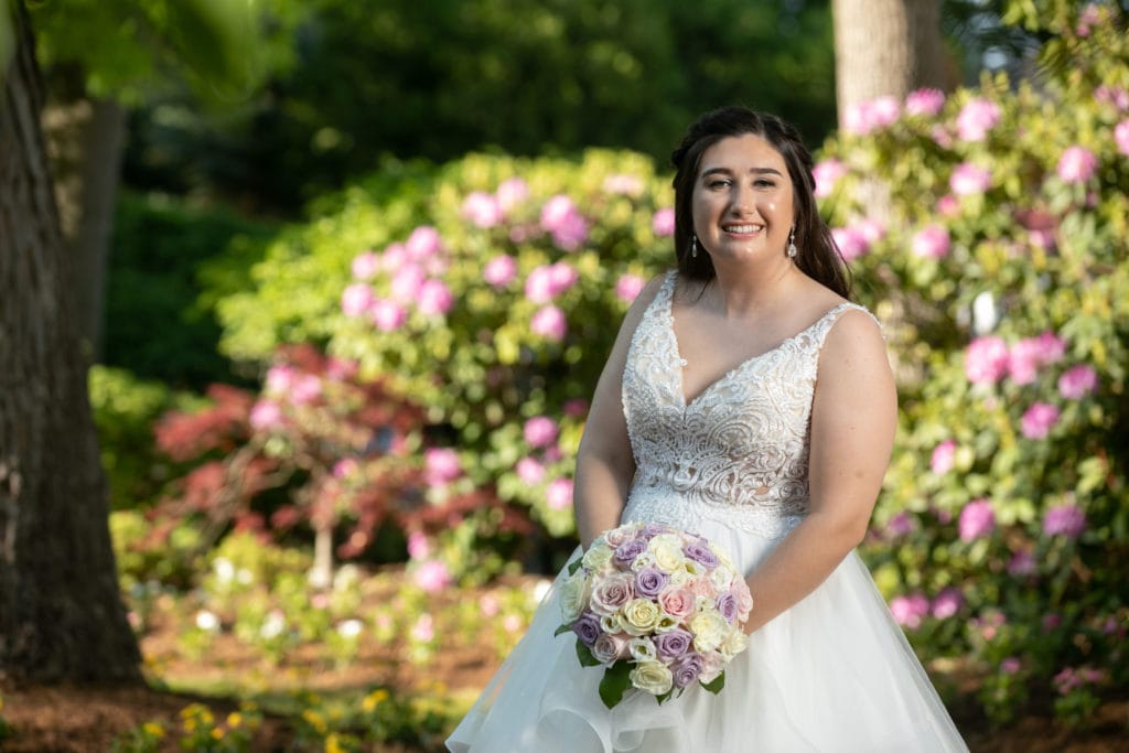 Plus-size White wedding dress and Curvy Bide posing in the outdoor gardens at the Tides Estate