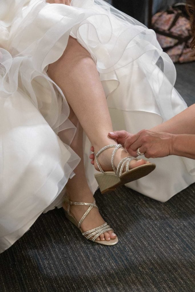 Plus size White wedding dress and Curvy Bide putting on shoes