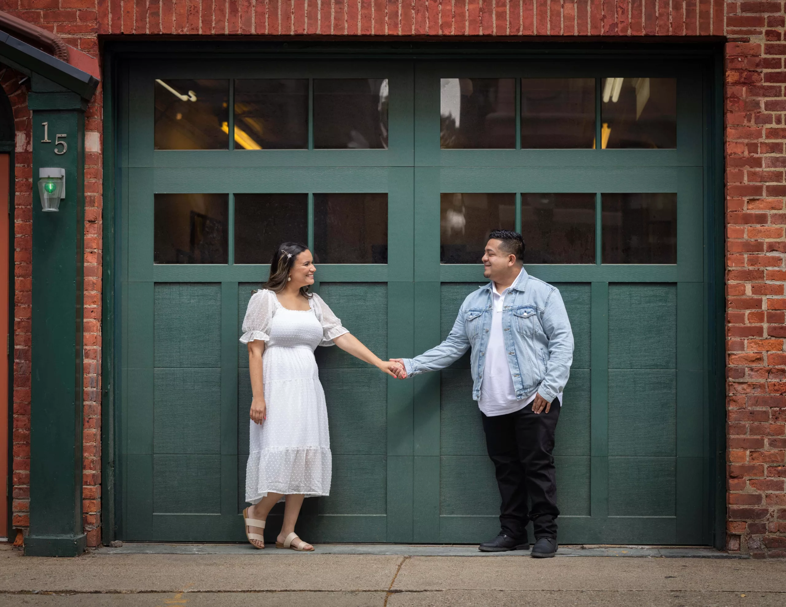 Engaged-couple-hispanic-standing-in-front-firehouse-door